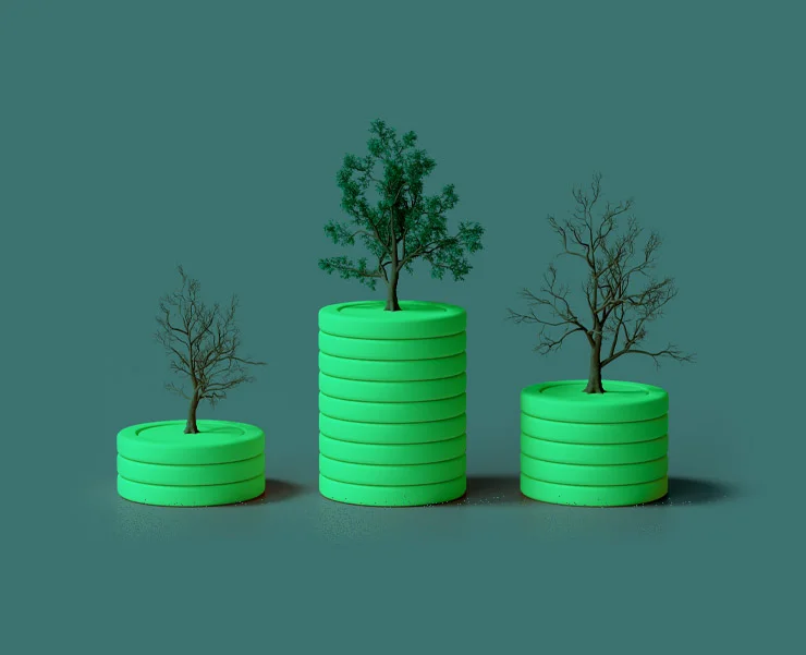 Three green coin stacks of varying heights with trees growing on top, representing growth, sustainability, or investment potential.