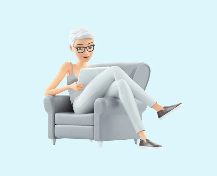 A woman with white hair and glasses sitting comfortably in a grey armchair, reading a tablet.