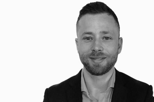 Black and white portrait of Matthew Jacobson, a senior financial adviser at Actonwealth, featuring him smiling in a professional suit.