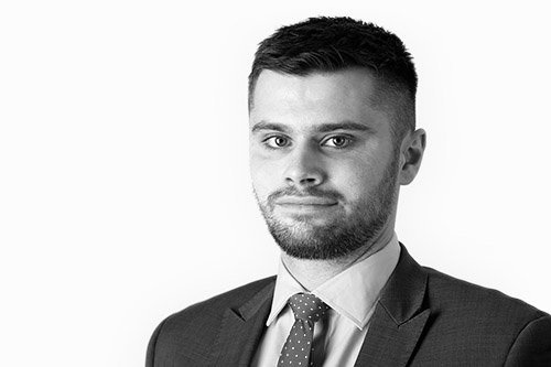 lack and white portrait of Thomas Daykin, a Senior Financial Adviser at Actonwealth, looking directly at the camera with a focused expression, dressed in a professional suit.