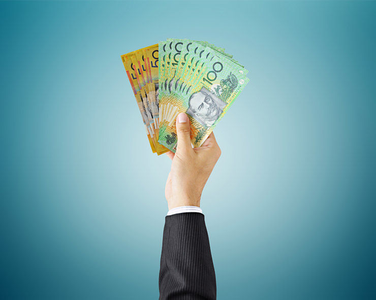 Hand holding Australian dollar bills in business suit for financial success