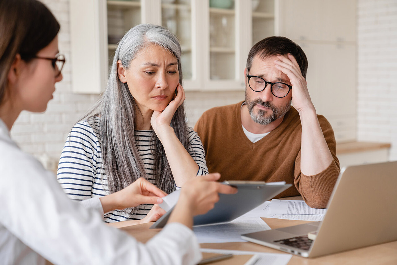 Concerned middle-aged couple receiving financial advice from a consultant